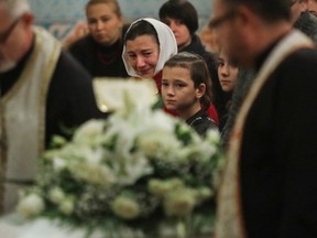 Galyna Legenkovska (in kerchief) and her children watch as the coffin with her daughter Mariia is brought to the front of the church during a memorial service at Sainte-Sophie Ukrainian Orthodox Cathedral on Tuesday.