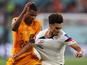 Denzel Dumfries of Netherlands battles for possession with Antonee Robinson of United States during the FIFA World Cup Qatar 2022 Round of 16 match at Khalifa International Stadium in Doha, Qatar, Saturday, Dec. 3, 2022.