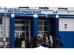 A crowd waits outside of Boyle Street Community Services at 101 Street on a cold day in Edmonton on Monday, Jan. 3, 2022.