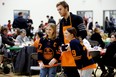 The Edmonton Oilers' Connor McDavid poses for photos as he helps serve a Christmas dinner to families served by the Hope Mission’s Kids In Action program, at Edmonton's Ivor Dent School, Thursday Dec. 8, 2022. Organizers estimate that over 360 meals were served. Photo By David Bloom