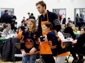 The Edmonton Oilers' Connor McDavid poses for photos as he helps serve a Christmas dinner to families served by the Hope Mission’s Kids In Action program, at Edmonton's Ivor Dent School, Thursday Dec. 8, 2022. Organizers estimate that over 360 meals were served. Photo By David Bloom