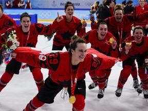 Canada's Marie-Philip Poulin (29) and teammates celebrate their gold medals after their win over archrival United States at the 2022 Winter Olympics, Thursday, Feb. 17, 2022, in Beijing.