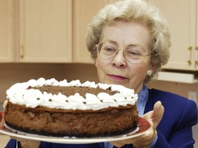 Jean Paré holds a chocolate cheesecake in the Company's Coming recipe testing kitchen.