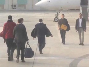 This video grab taken from a footage shown by Russian state media shows U.S. basketball star Brittney Griner, wearing a red jacket on the left, during a prisoner swap with Viktor Bout, a notorious Russian arms dealer on December 8, 2022 on the tarmac of Abu Dhabi airport.