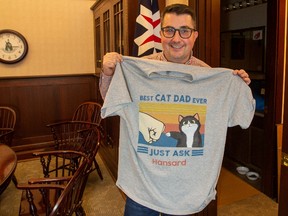 Even when he's out of office, Hansard the cat links the Albertans to the legislature Speaker Nathan Cooper poses wearing a shirt given to him by Hansard Department staff on December 1, 2022.