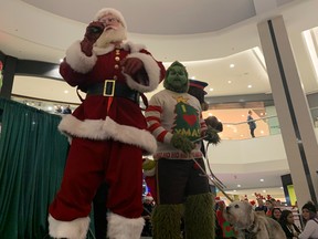Santa Claus, left, the Grinch and dog Max at the first Operation Find Santa event from the Edmonton Police Foundation and Bent Arrow at West Edmonton Mall on Saturday, Dec. 10, 2022.