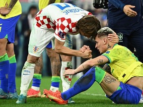 Croatia's midfielder #10 Luka Modric comforts Brazil's forward #19 Antony after qualifying to the next round after defeating Brazil in the penalty shoot-out of the Qatar 2022 World Cup quarter-final football match between Croatia and Brazil at Education City Stadium in Al-Rayyan, west of Doha, on December 9, 2022.