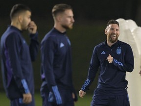Argentina's forward Lionel Messi (R) laughs during a training session at Qatar University in Doha on December 12, 2022, on the eve of the Qatar 2022 World Cup semi final football match between Argentina and Croatia.