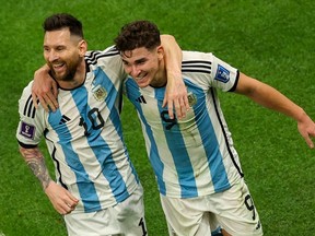 Argentina's forward #09 Julian Alvarez celebrates with Argentina's forward #10 Lionel Messi (L) after scoring his team's second goal during the Qatar 2022 World Cup football semi-final match between Argentina and Croatia at Lusail Stadium in Lusail, north of Doha on December 13, 2022.