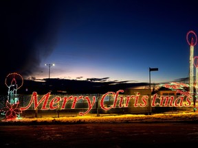 The sun sets behind a light exhibit at the Borealis Lights, a Christmas drive-thru light display located in St. Albert, Alberta, which runs until January 8, 2023.