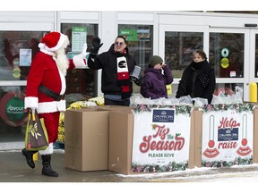 Santa waves to Daniel "Can Man Dan" Johnstone as Johnstone continues his three day winter camp out for the Edmonton Food Bank at the Southbrook Sobey's, 1109 James Mowatt Trail SW, Saturday, Dec. 24, 2022. Photo By David Bloom