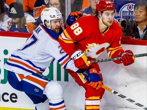 Edmonton Oilers Brett Kulak battles against Andrew Mangiapane of the Calgary Flames during NHL hockey at the Scotiabank Saddledome in Calgary on Tuesday, December 27, 2022. AL CHAREST/POSTMEDIA