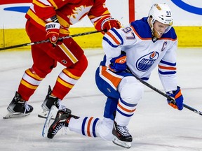 Connor McDavid of the Edmonton Oilers after a taking a hit from Mackenzie Weegar of the Calgary Flames during NHL hockey at the Scotiabank Saddledome in Calgary on Tuesday, Dec. 27, 2022.