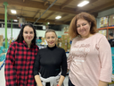 Daryna Partynovska, left, Olena Gorshkova and Iuliia Bashtanova stand at Edmonton's Food Bank’s warehouse on Dec. 13, 2022. The three women said they’ve benefited from Beyond Food, a job readiness program offered at the food bank.