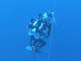 A team of five rescuers from Roatan Freediving School swim to Miguel Lozano’s aid and work to rapidly push his limp body to the surface from 410 feet.