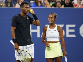 Canada's Felix Auger-Aliassime, and Leylah Fernandez, talk to John McEnroe during a "The Tennis Plays for Peace" exhibition match to raise awareness and humanitarian aid for Ukraine, in New York, Wednesday, Aug. 24, 2022. Auger-Aliassime and Fernandez won in the men's and women's singles categories respectively.