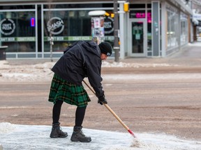 Mitch with Men in Kilts clears packed snow from a sidewalk along Whyte Avenue on Friday December 23, 2022. Greg Southam-Postmedia