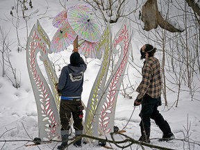 Gene Whipple, left, and Dylan Twomaker install technical lighting at Mill Creek Ravine on Monday, March 1, 2021, in preparation for a light installation for the Flying Canoe Volant, which will take place February 1-4 of this year.