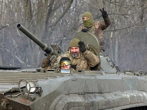 Ukrainian soldiers ride an armoured personnel carrier near Bakhmut, in Ukraine's eastern region of Donetsk, on Jan. 17, 2023. Canada is donating 200 armoured personnel carriers to the Ukrainian forces, Minister Anita Anand has announced. The vehicles are being manufactured in Mississauga, Ont., by Roshel, which employs approximately 80 Ukrainians who have come to Canada.
