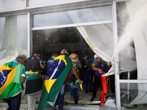 Supporters of Brazil's former President Jair Bolsonaro break into a building during a demonstration against President Luiz Inacio Lula da Silva, in Brasilia, Brazil, Sunday, Jan. 8, 2023.