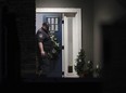 A law enforcement official stands at the front door of the Enoch, Utah, home where eight family members were found dead from gunshot wounds, Wednesday, Jan. 4, 2023.