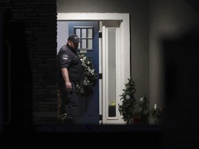 A law enforcement official stands at the front door of the Enoch, Utah, home where eight family members were found dead from gunshot wounds, Wednesday, Jan. 4, 2023.