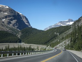 Highway 93: Vehicles drive along Highway 93N, near the big bend in Banff National Park, showing expansive views of the valley and surrounding mountain range 2021.