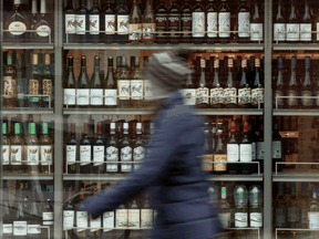 A person walks past shelves of bottles of alcohol on display at an LCBO in Ottawa.