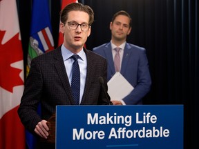 Minister of Affordability and Utilities Matt Jones (background) and Minister of Technology and Innovation Nate Glubish provide an update on $600 support payments coming to some families and seniors, during a press conference at the Alberta Legislature in Edmonton, Monday Jan. 9, 2023. Photo By David Bloom