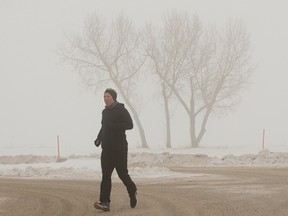 A jogger makes their way through the fog at the University of Alberta Farm in Edmonton, Tuesday Jan. 10, 2023. Environment Canada issued a special air quality statement for Edmonton and surrounding areas.