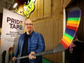 Kristopher Wells holds a Pride-taped hockey stick at Clare Drake Arena in Edmonton, Alberta on Dec. 17, 2015. Pride Tape was announced as a badge of support from the hockey world to the LGBTQ youth.