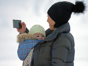 Multi-tasking mom Keiko Mihara and her baby Kayelle enjoy the mild -7 C temperatures in Edmonton on Jan. 2, 2023.