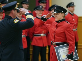 Recruit firefighter Kenna Sadler, right, the only woman to graduate in Edmonton Fire Rescue Service's October 2022 recruit class, salutes Edmonton Fire Chief Joe Zatylny at the Italian Cultural Centre in northwest Edmonton. EFRS has changed its recruitment process to make it more fair and equitable, firefighters say.