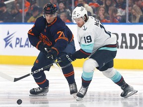 Jan 3, 2023; Edmonton, Alberta, CAN; Edmonton Oilers forward Klim Kostin (21) and Seattle Kraken forward Jared McCann (19) battle for the puck during the first period at Rogers Place. Mandatory Credit: Perry Nelson-USA TODAY Sports