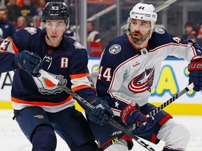 Edmonton Oilers forward Ryan Nugent-Hopkins (93) and Columbus Blue Jackets defencemen Erik Gudbranson (44) look for a loose puck during the third period at Rogers Place on Wednesday, Jan. 25, 2023.