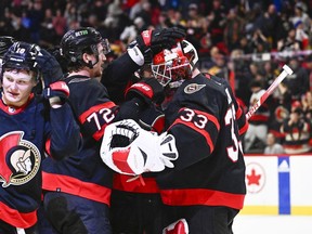 Ottawa Senators goaltender Cam Talbot (33) is congratulated by teammates after their win in the shootout against the Boston Bruins in NHL hockey action in Ottawa, on Tuesday, Dec. 27, 2022.