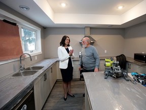 Premier Danielle Smith, left, and Dr. Louis Francescutti look at the communal kitchen in a new 36-bed transition facility referred to as the Bridge Healing Transitional Accommodation Program at 16022 100 Ave., in Edmonton on Jan. 12, 2023.