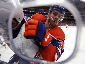 The Edmonton Oilers' Connor McDavid (97) checks the New York Islanders' Casey Cizikas (53) during second period NHL action at Rogers Place, in Edmonton, Thursday, Jan. 5, 2023.
