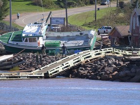 A lobster boat grounded on the rocks at the wharf in Stanley Bridge, P.E.I. on Sunday September 25, 2022. The federal government is providing up to $40 million over two years to shellfish farmers in Atlantic Canada to help them recover from damage caused by post-tropical storm Fiona.