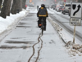 Making tracks as cyclist uses the bike lane along 83 Ave. during a brief snow fall moving through Edmonton, February 4, 2020.