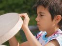 Brant Janvier's child making their drum.?Image from the film Heartbeat of a Nation. Courtesy of the National Film Board of Canada, 2022.