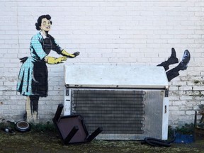 An artwork, acknowledged to by street artist Banksy, is pictured on the side of a house in Margate, south east England on February 14, 2023. - The artwork appears to show a a 1950s housewife with a swollen eye, missing a tooth, and apparently shutting a man in a freezer. The freezer was later removed by council workers.