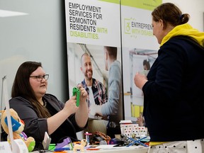 Heather Buerfeind, left, from Makers Making Change, demonstrates 3D printed adaptive devices during the Person’s with Disabilities Community Resource Fair put on by Prospect Human Services Edmonton, at Suite 318 Kingsway Mall on Feb. 22, 2023.