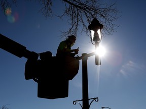 Devin Westendorf from Can-Traffic Services LTD. works to repair a light standard along Gateway Boulevard north of 82 Avenue in Edmonton, Monday, Feb. 27, 2023.