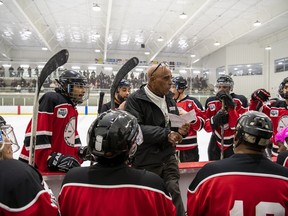 Honourary head coach John Paris Jr., centre, speaks with an all-Black roster representing the Dartmouth Jubilees at a game commemorating the history of the Colored Hockey League of the Maritimes at the RBC Centre, in Dartmouth, N.S., in a Saturday, Feb. 18, 2023, handout photo. A grassroots effort is underway to get John Paris Jr., the first Black professional coach in hockey, to be inducted into the Hockey Hall of Fame.