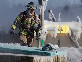 Petugas pemadam kebakaran di lokasi kebakaran rumah di 223 dan 235 Glenridding Ravine Road SW di Edmonton, Jumat, 24 Februari 2023. Foto Oleh David Bloom