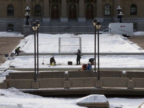 Para kru mengerjakan air mancur di Alberta Legislature di Edmonton, Selasa, 7 Februari 2023.