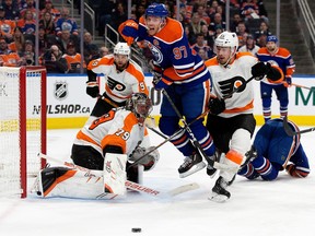 The Edmonton Oilers' Connor McDavid (97) battles the Philadelphia Flyers' goalie Carter Hart (79) and Rasmus Ristolainen (55) during third period NHL action at Rogers Place in Edmonton, Tuesday, Feb. 21, 2023. The Oilers won 4-2.