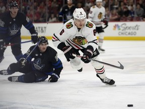 Chicago Blackhawks defenseman Jake McCabe, right, chases the puck during the first period of an NHL hockey game against the Toronto Maple Leafs, Sunday, Feb. 19, 2023, in Chicago. The Toronto Maple Leafs have acquired McCabe and forward Sam Lafferty in a trade with the Chicago Blackhawks.THE CANADIAN PRESS/AP-Erin Hooley