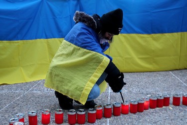 Edmontonians light candles as they mark the one-year anniversary of Russia's full-scale invasion of Ukraine with a vigil outside the Alberta Legislature in Edmonton, Friday Feb. 24, 2023.